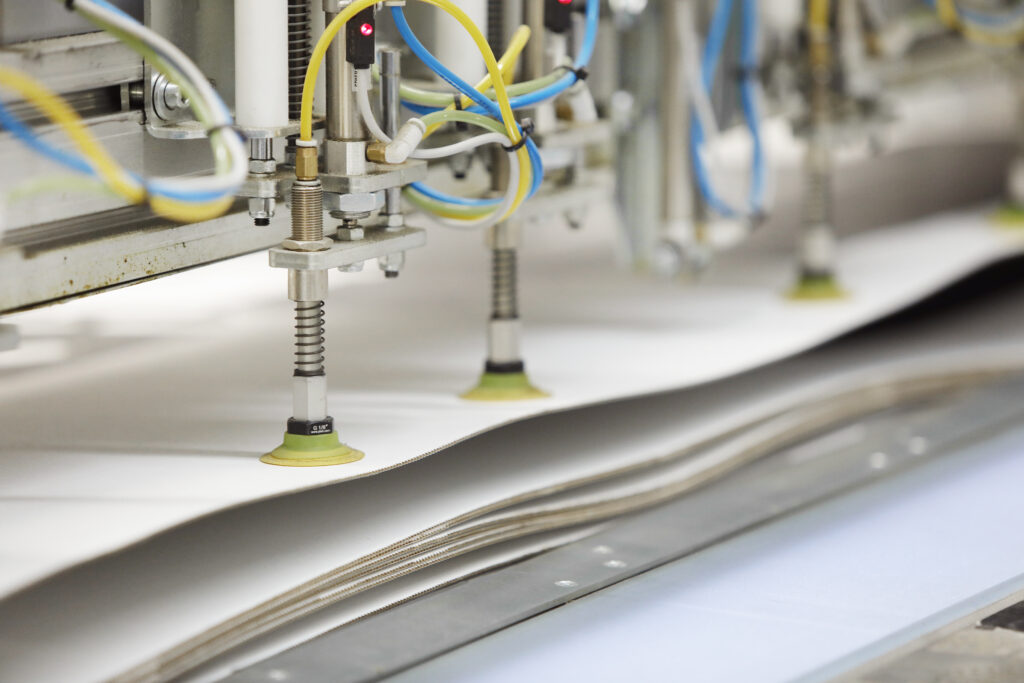 Suction cups on the Airo Panel lifting a cut sheet off the cutting table of an Elitron Kombo TAV-R at VT Group